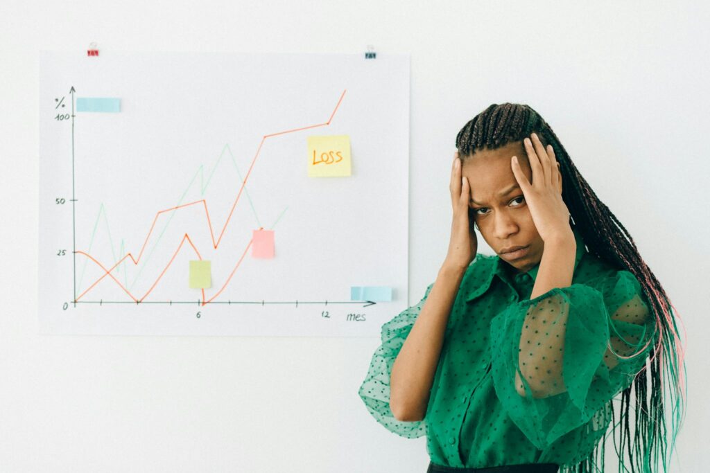 Businesswoman analyzing financial chart with loss noted, expressing stress.